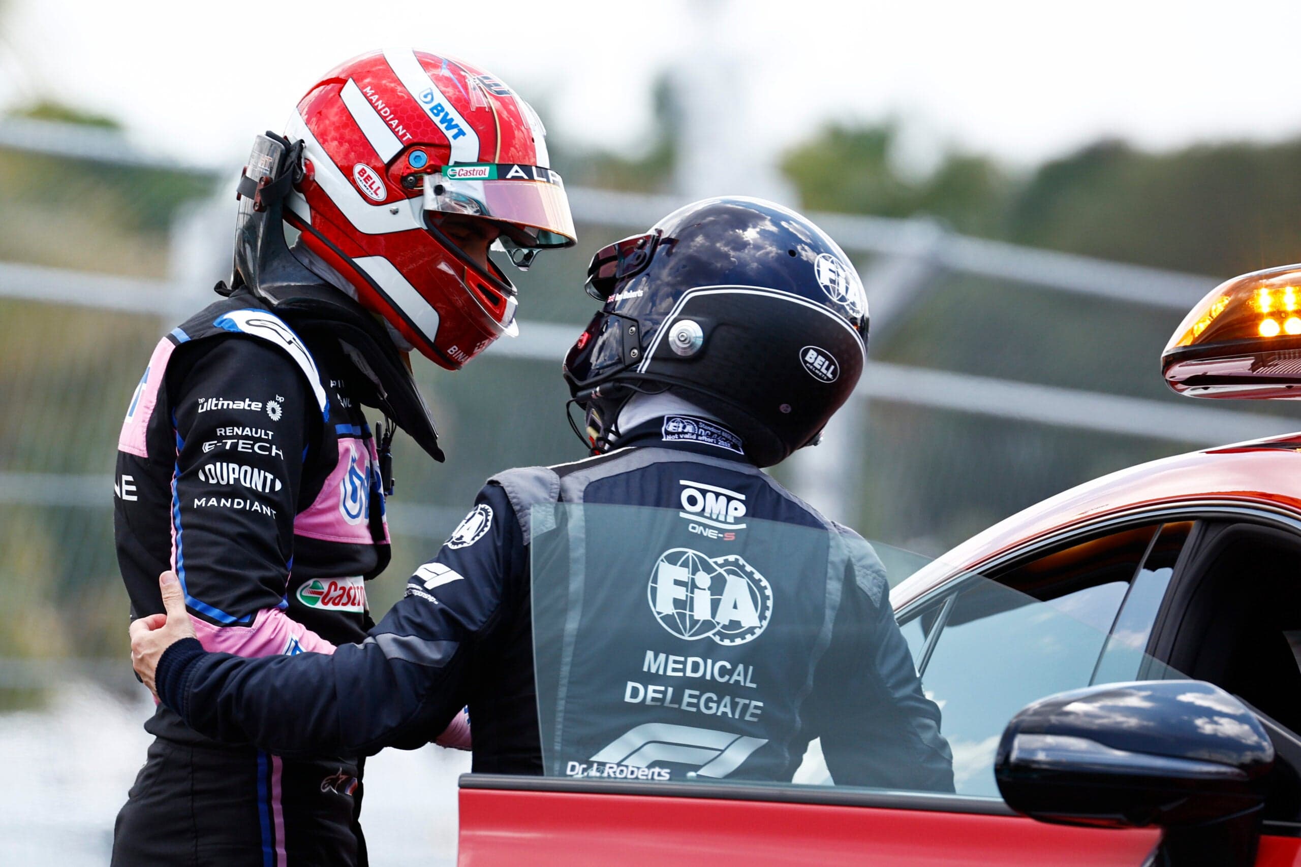 Esteban Ocon being helped into the F1 medical car by medical personnel