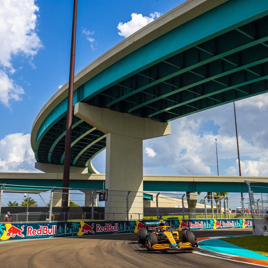Lando Norris driving through the tight chicane in Miami, under a road overpass
