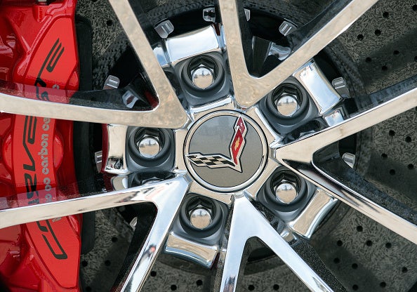 A close-up of a chrome Chevrolet Corvette wheel with red brake calipers. 