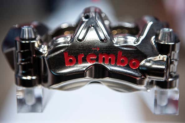 A close-up of a silver Brembo brake caliper. 