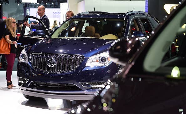 People inspect a Buick Enclave on display at the LA Auto Show