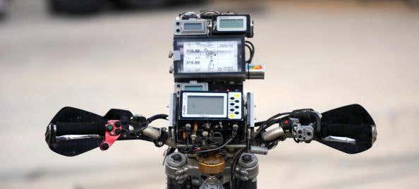 A GPS unit sits atop the gauge cluster of a motorcycle. 