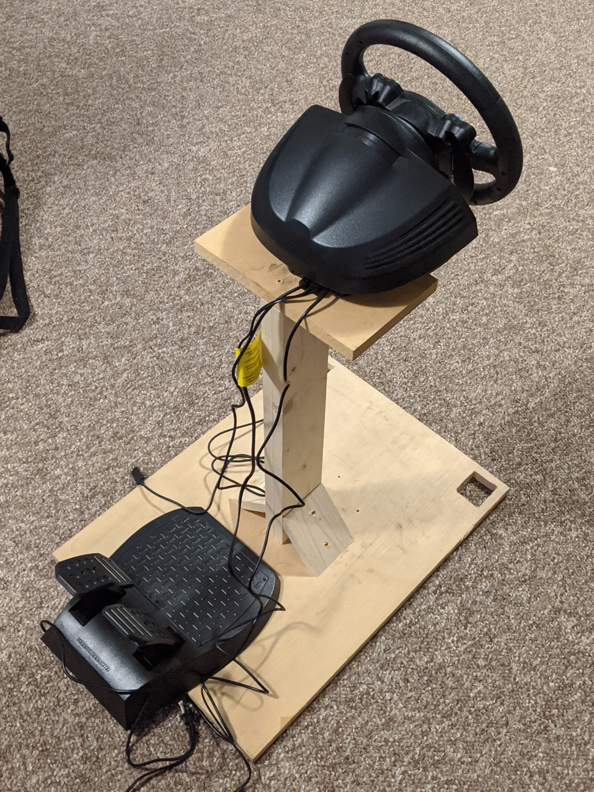 Race gaming rig with wheel and pedals on a wooden stand