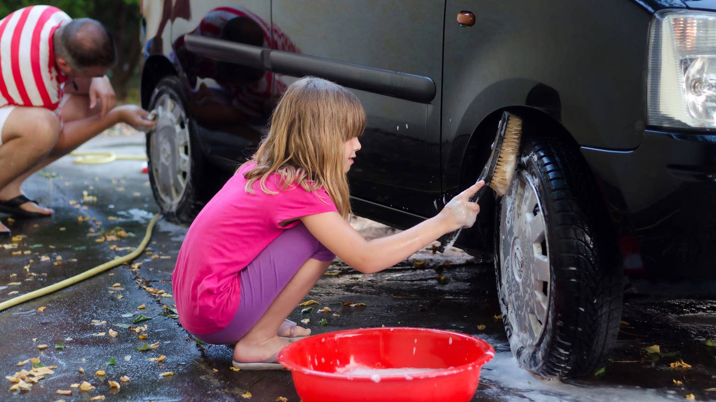 Use a hard-bristle brush to wash a car's tires.