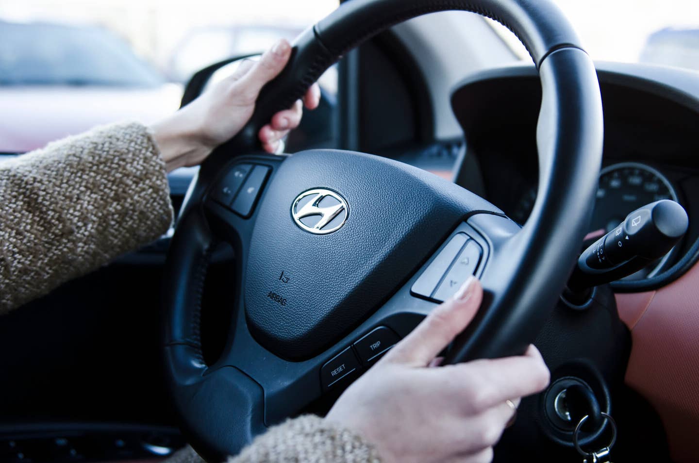 Hands holding steering wheel in hyundai car