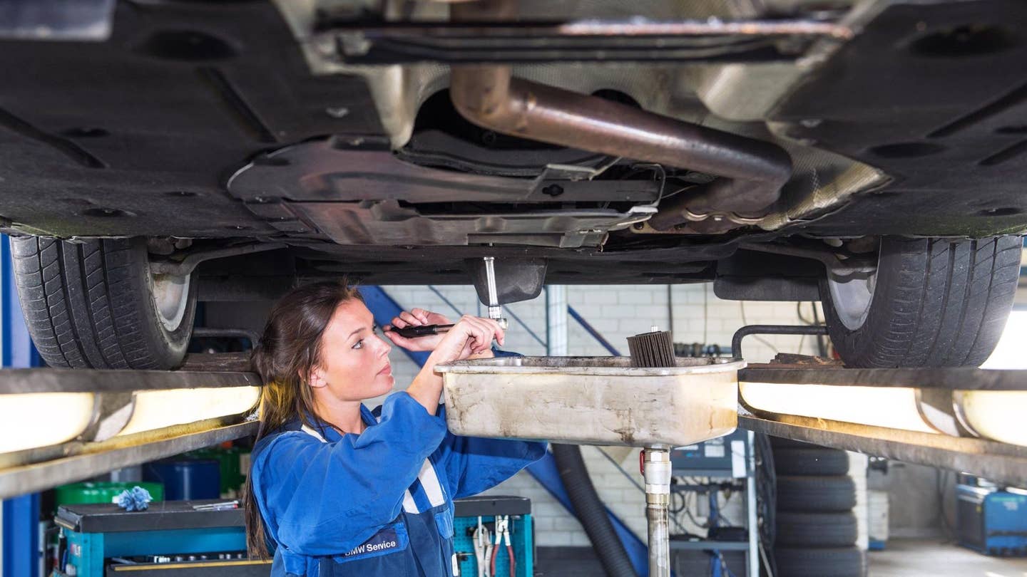 A mechanic performing an oil change. 