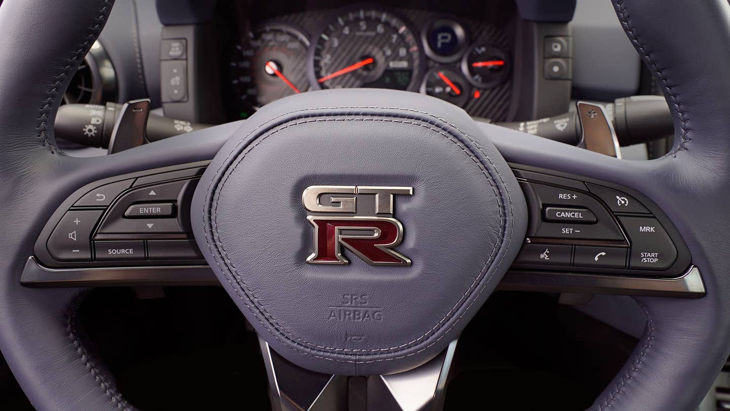 The steering wheel of a Nissan GT-R with paddle shifters.