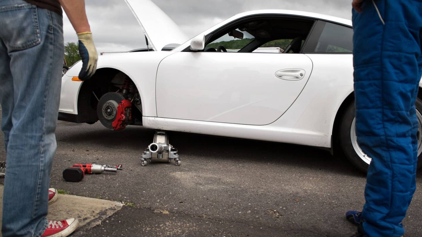 A Porsche's slotted, cross-drilled rotor is exposed. 