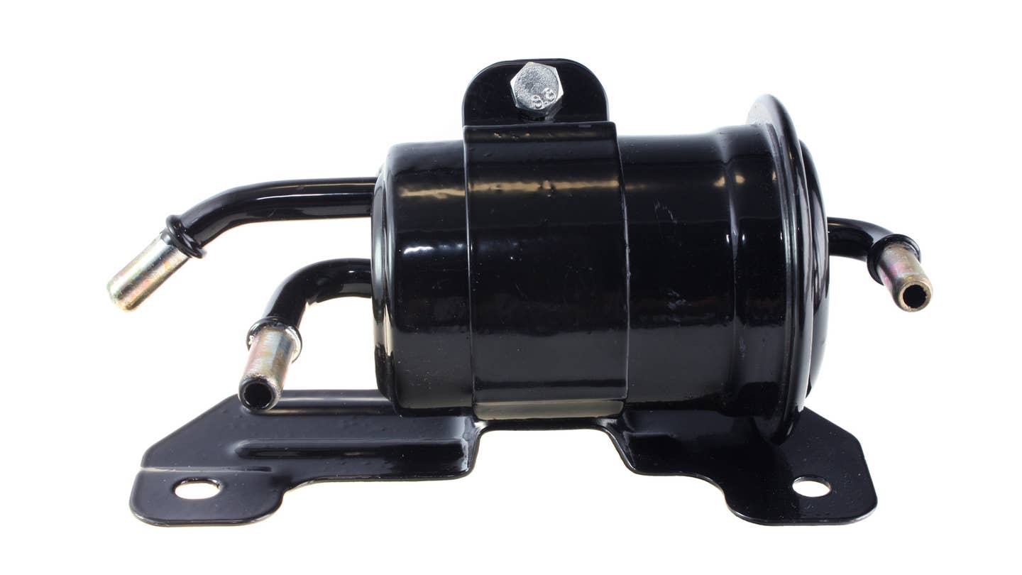 A black fuel filter sits inside a holding bracket over a white background.