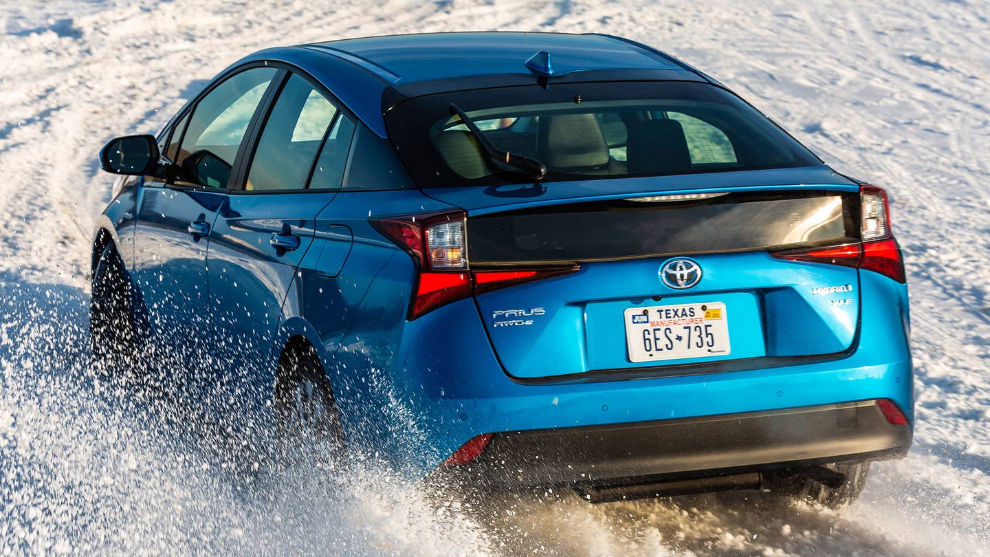 A blue Toyota Prius with AWD-e driving on white snow.
