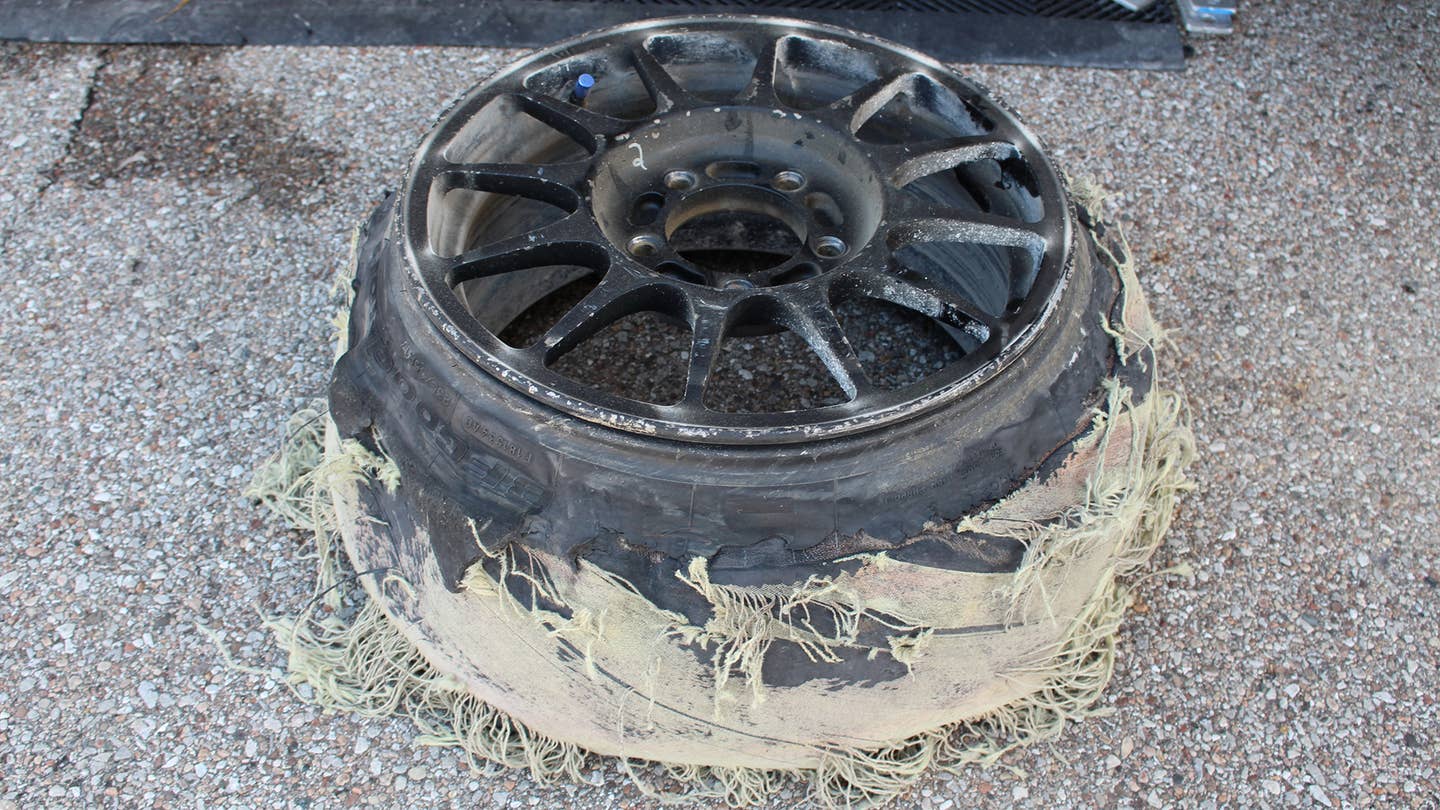 A shredded tire on a racing wheel.