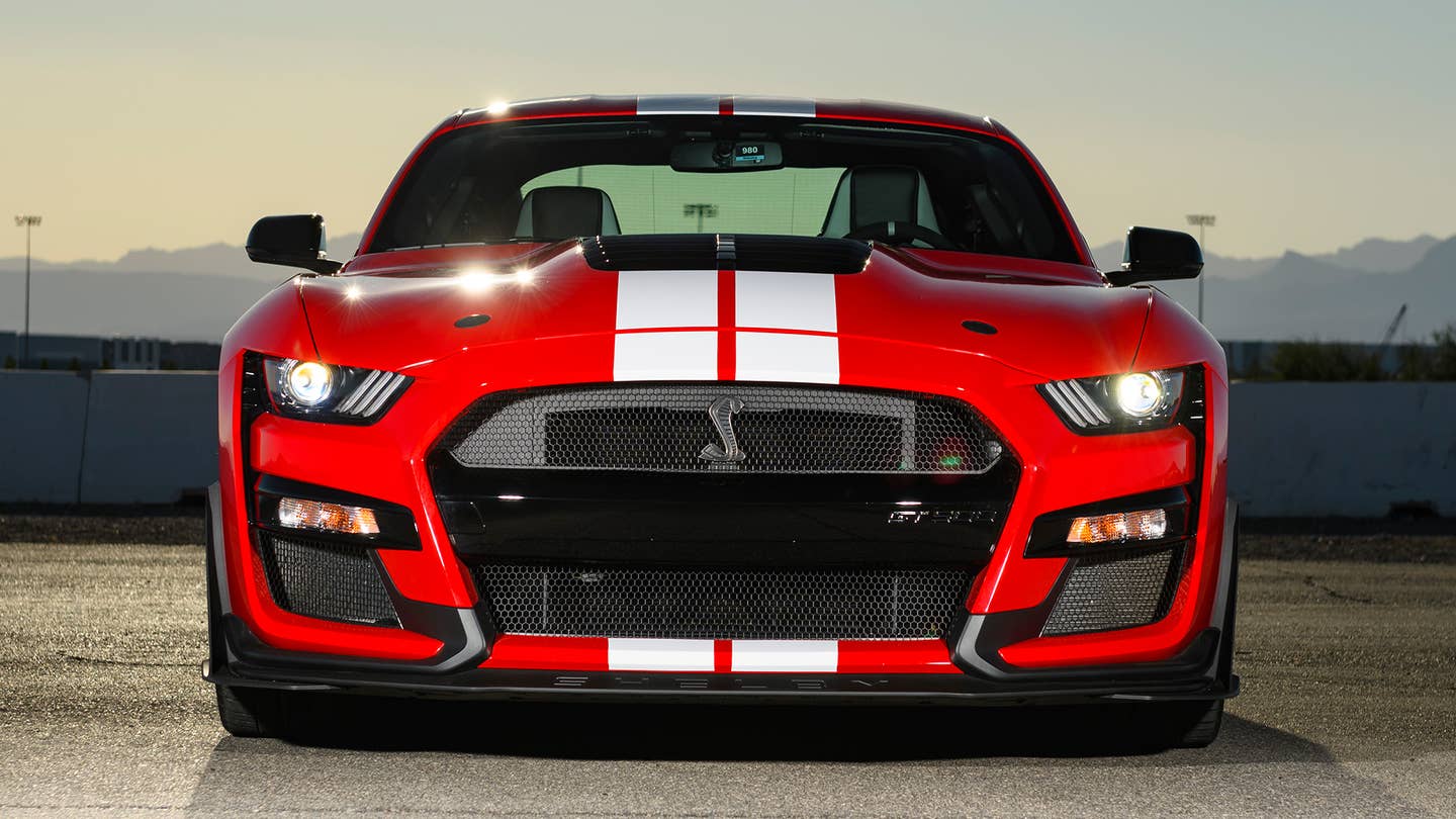 A red Ford Mustang Shelby GT500 faces the camera.