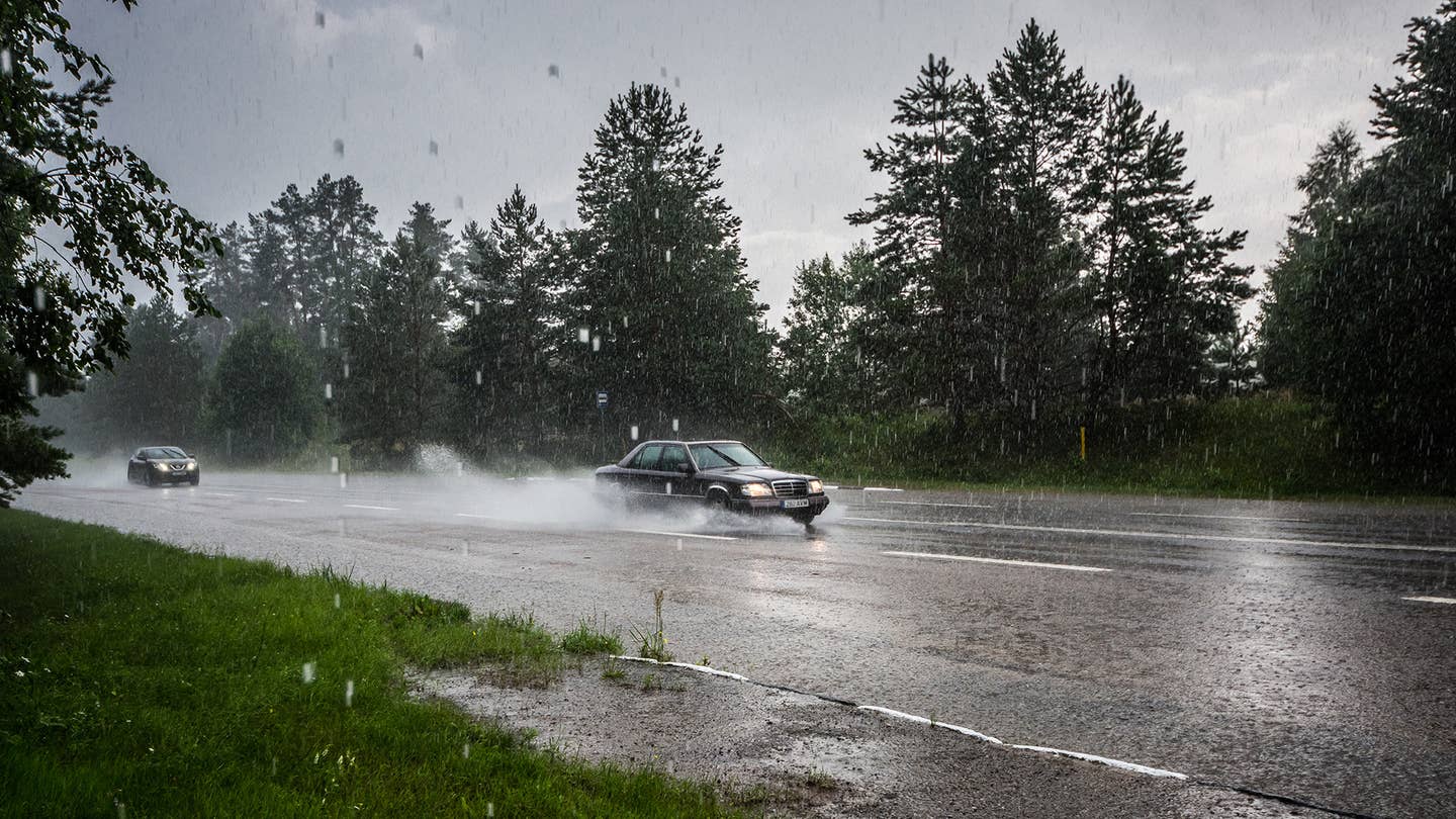 A Mercedes-Benz sedan driving in the rain.