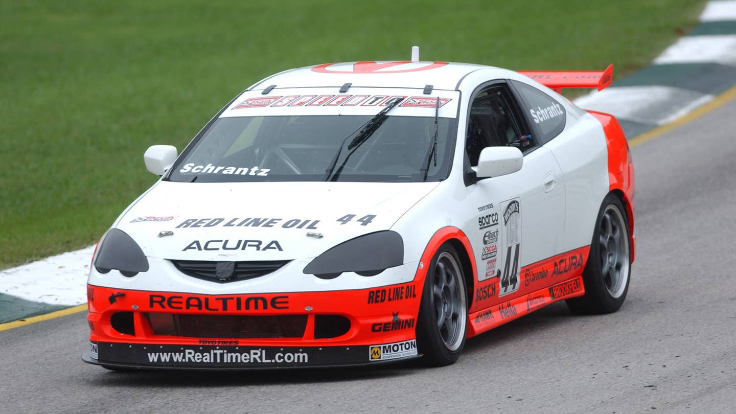 A Realtime Racing Acura RSX Type S on the track in white and orange livery.