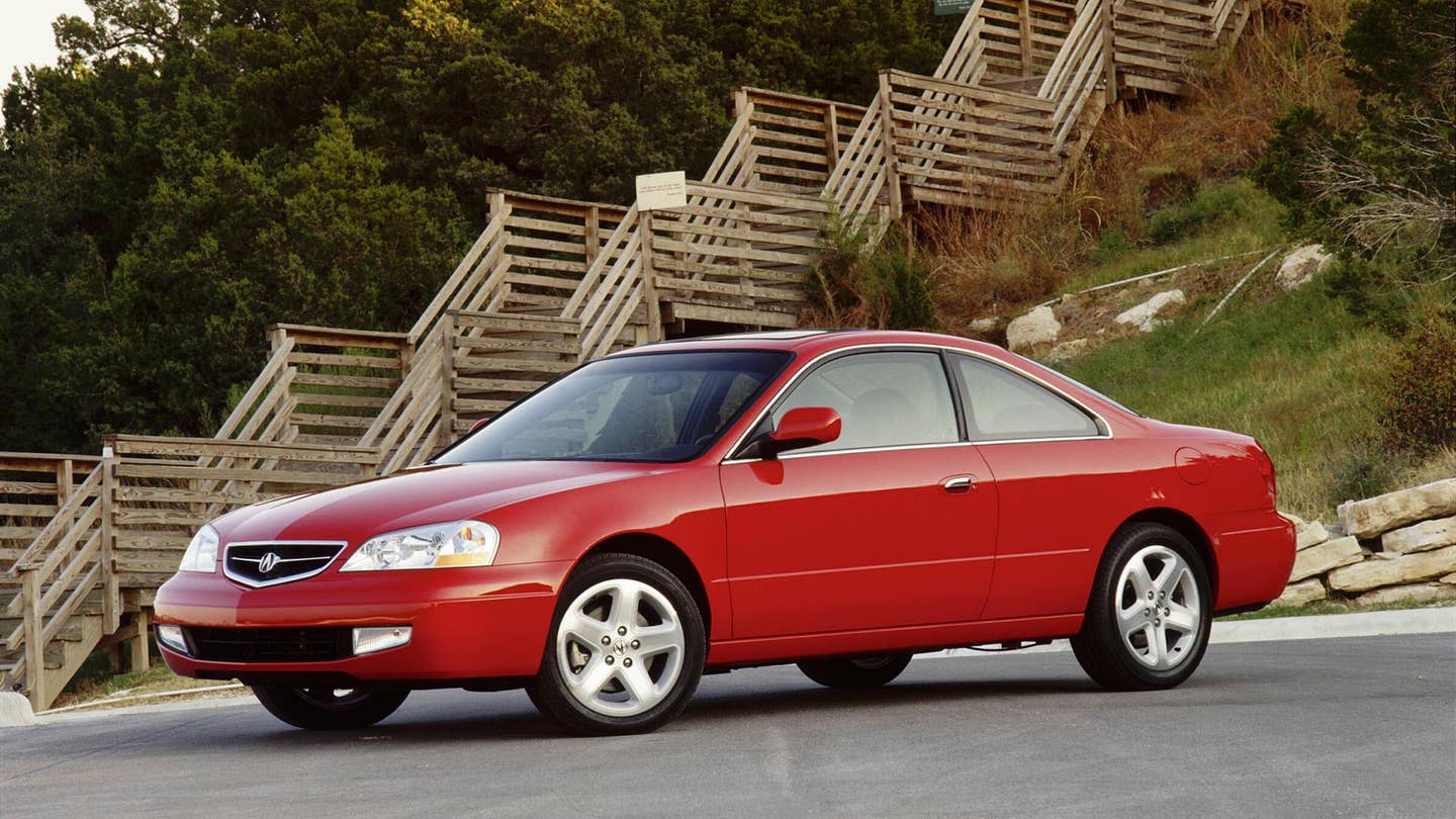 A red 2001 Acura 3.2CL Type S parked in front of wooden stairs.