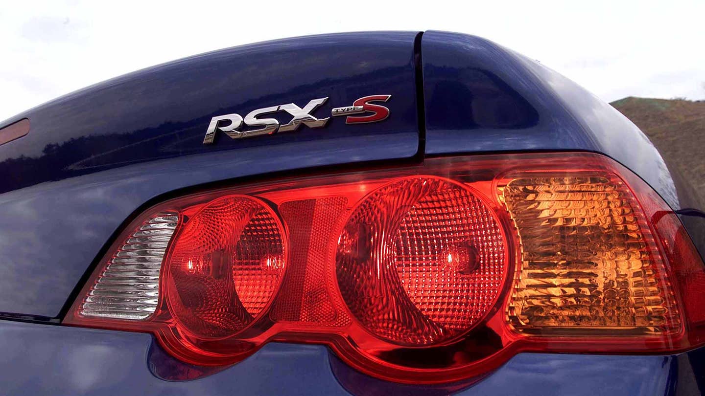 The rear lights of a blue 2002-2004 Acura RSX Type S.