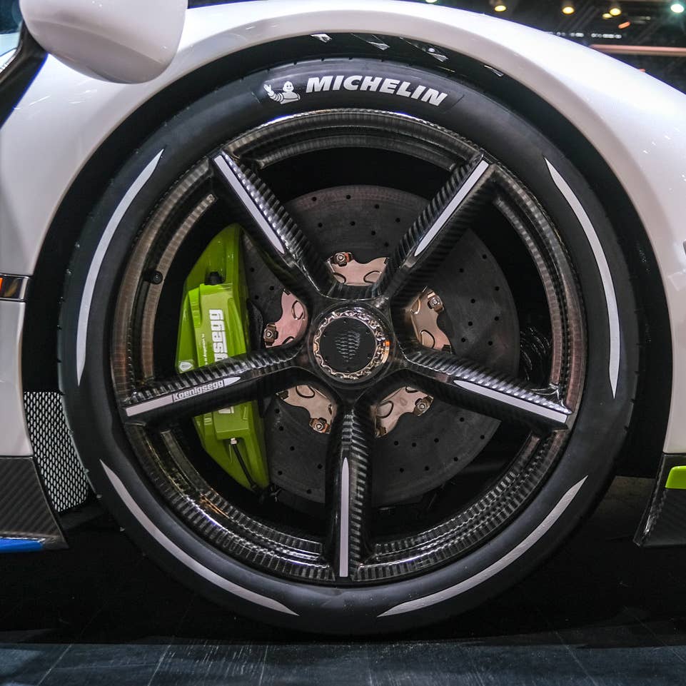 A carbon fiber Koenigsegg wheel at an auto show.