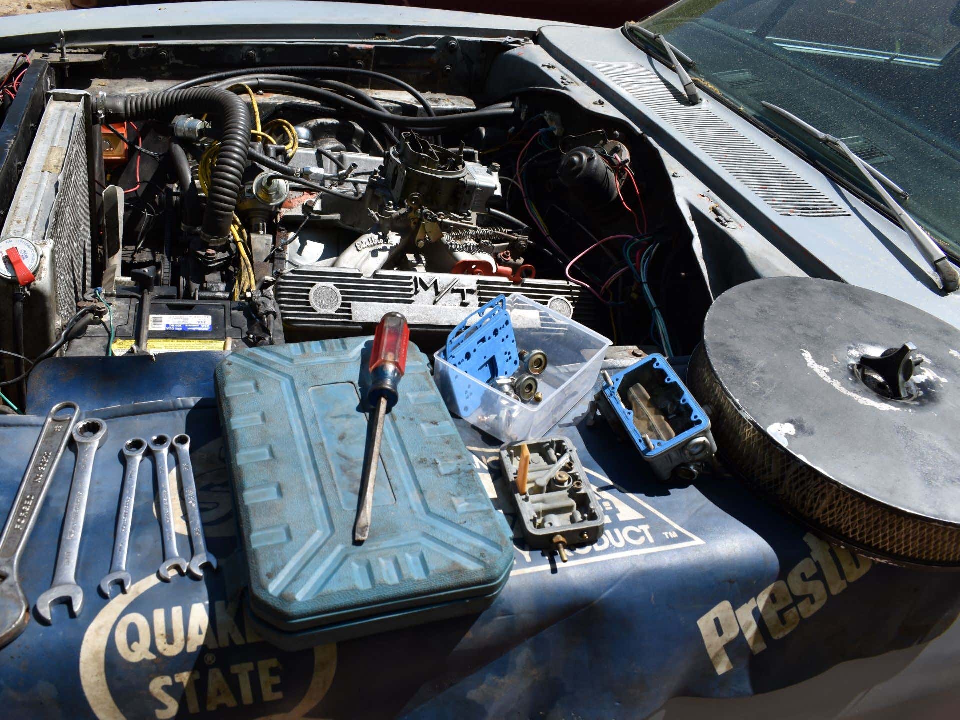 The engine and engine bay of a 1969 Dodge Charger with a Holley carburetor.