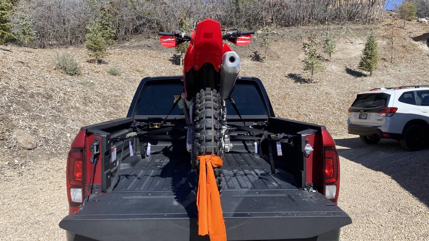 A red CRF450RX in the bed of a 2021 Honda Ridgeline.