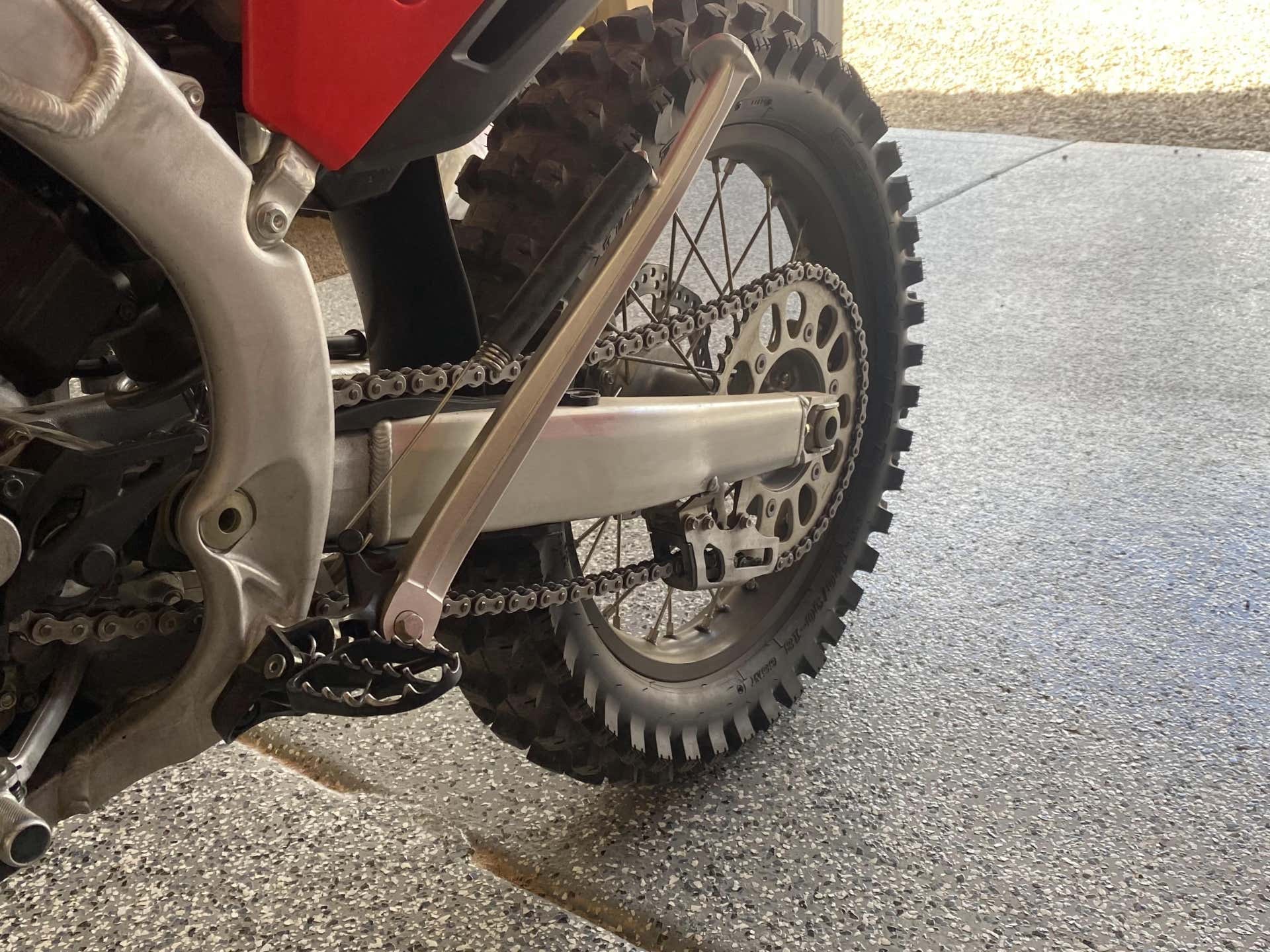 The full view of a CRF450RX's drivetrain and sprockets.