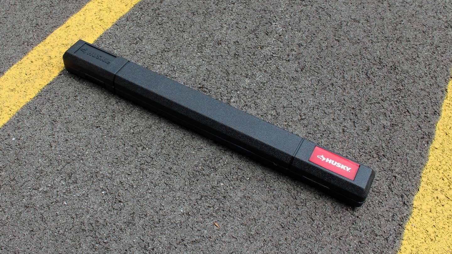 A Husky torque wrench with 1/2-inch Drive in its case on the ground.