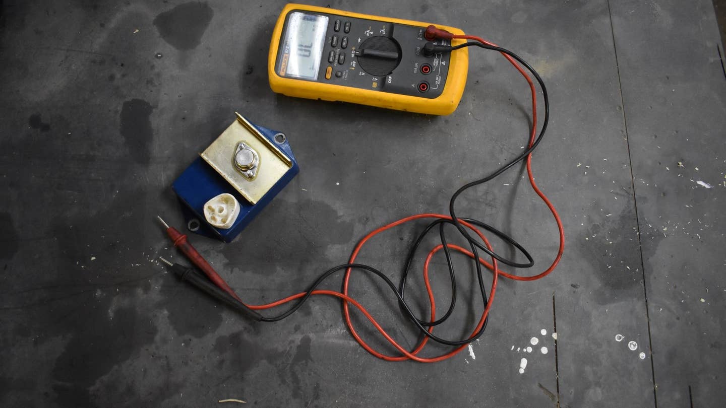 A multimeter checking an ignition module.