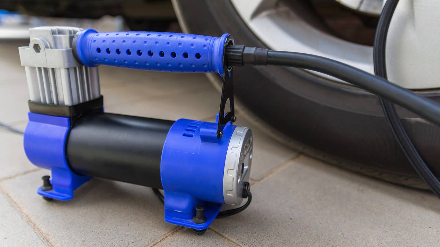 A blue tire inflator next to a wheel.