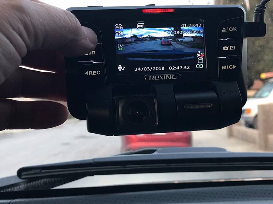 An up-close view of a dash cam with a screen and front- and rear-facing cameras.