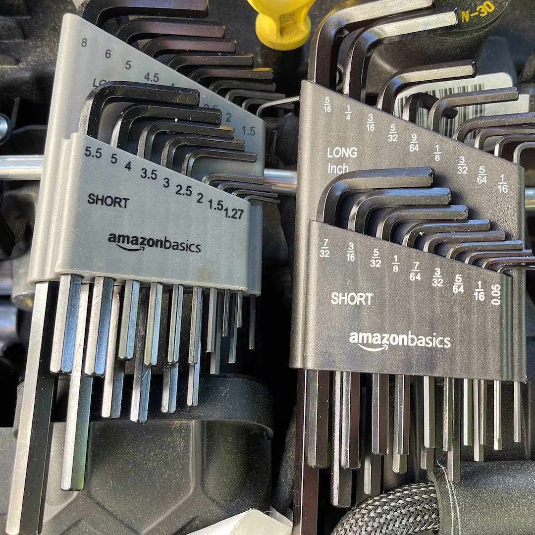 Two sets of Amazon Basics hex key sets on top of an engine.