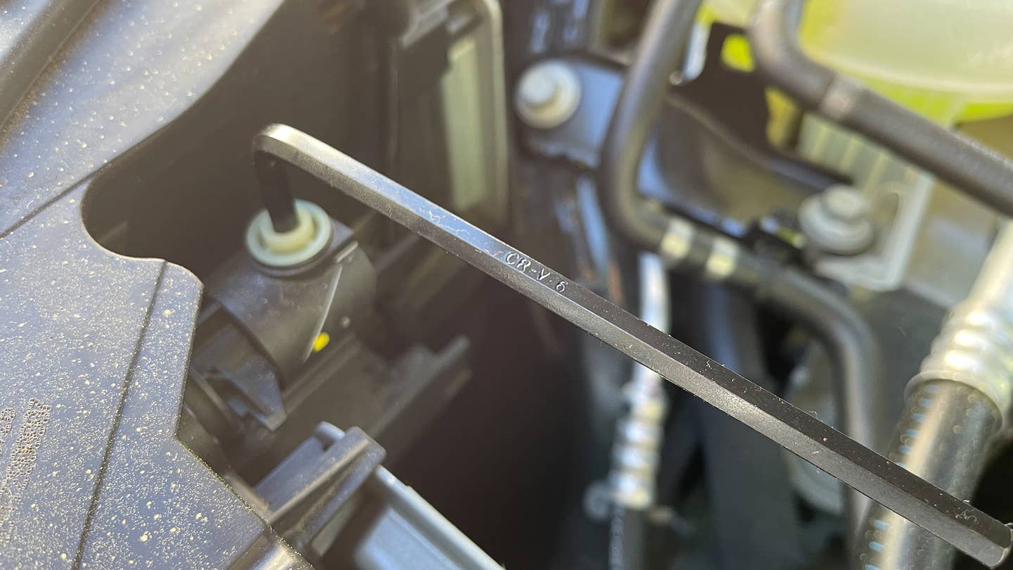A close-up view of a hex key set adjusting headlights.