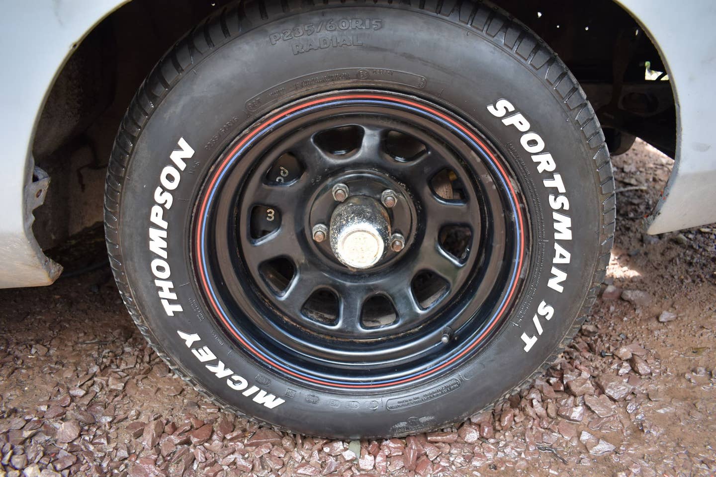 A close-up of a steel wheel with Mickey Thompson tires.