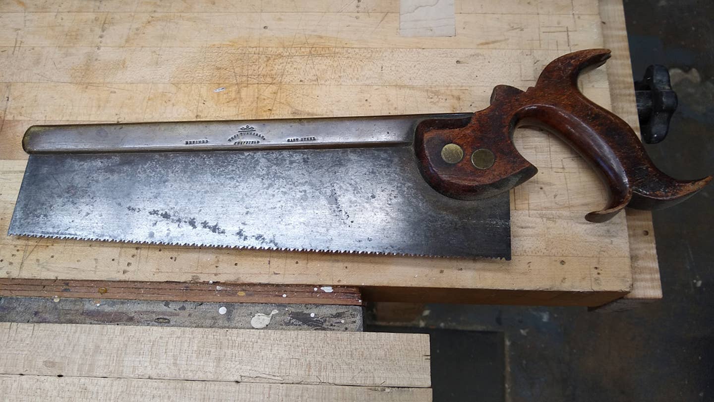 An old hand saw with a wooden handle.