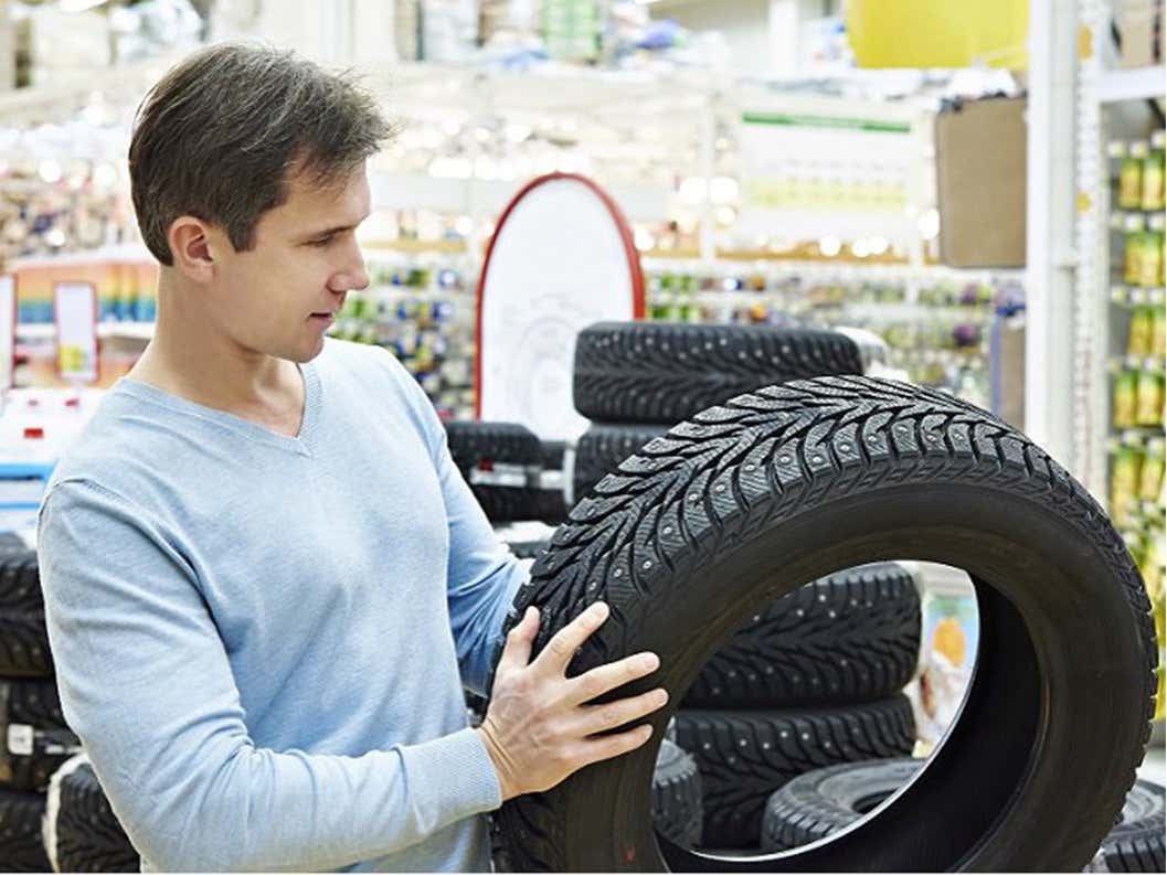 man inspecting tire at store