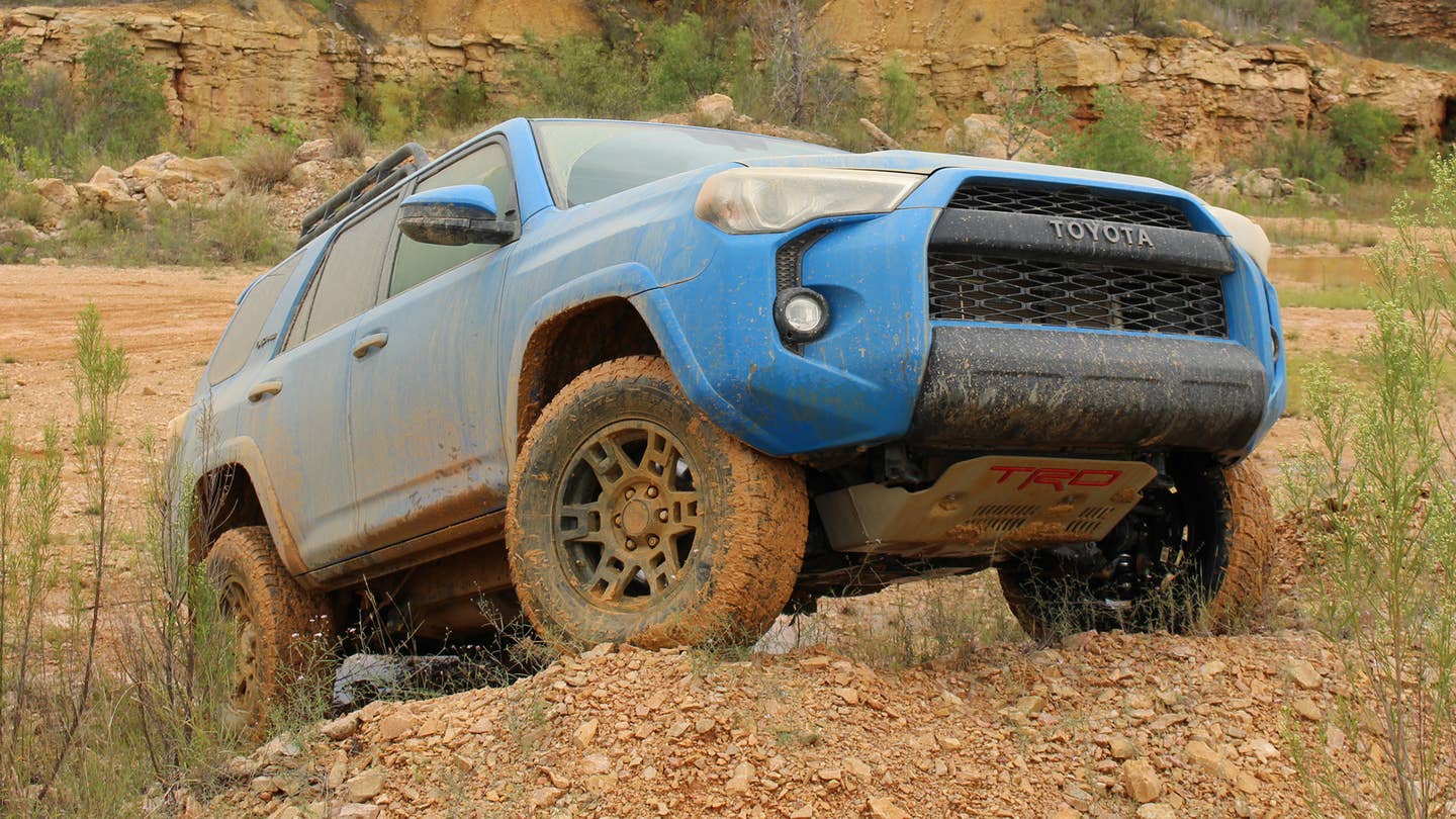 A blue Toyota Tacoma TRD Pro crawls over some rocky terrain in Texas.