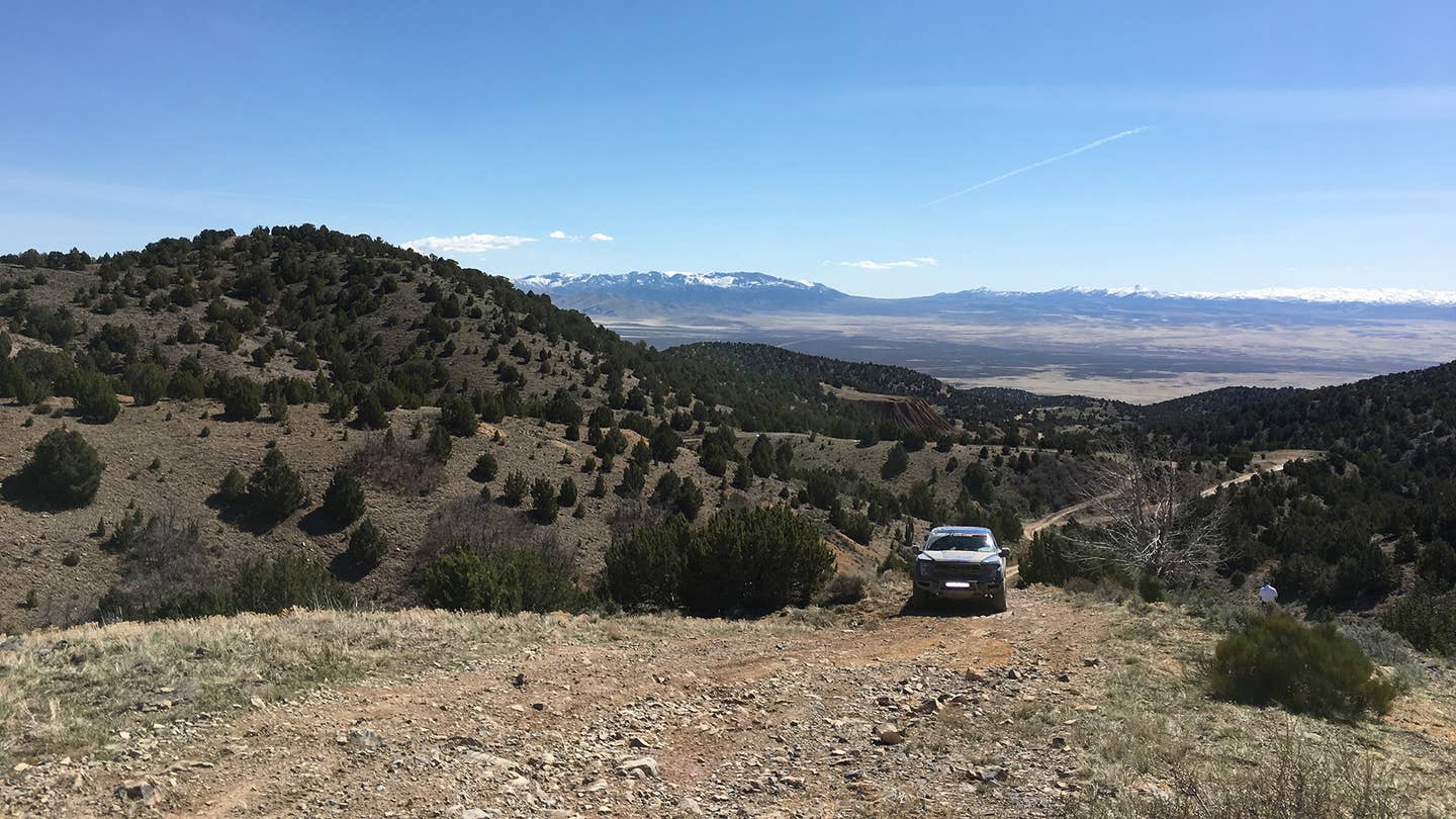 The stunning view of the valley and distant snow-capped mountains from an off-road mountain trail. 