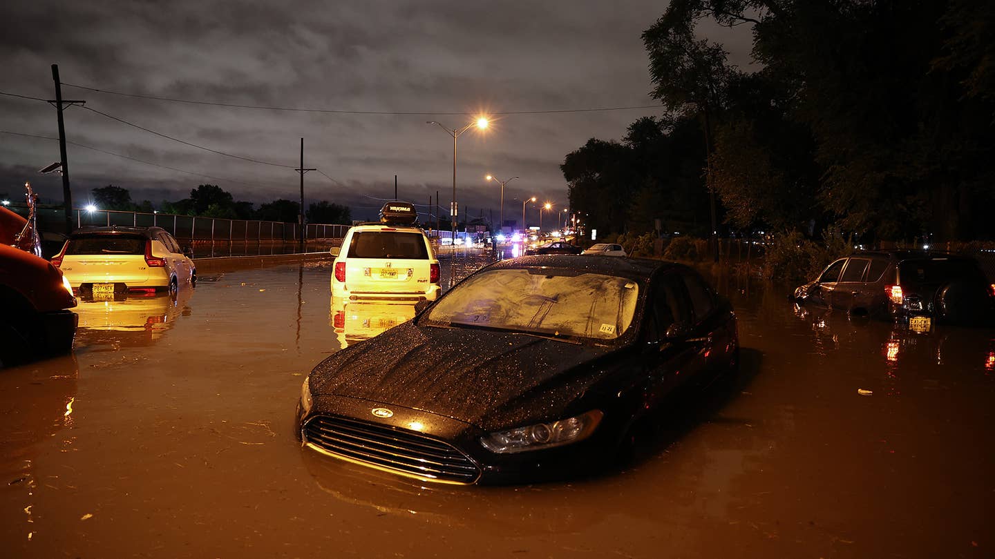 A Volv XC40, a Ford Fusion, a Honda Pilot, and a Toyota Rav4 sit in flood waters at night.