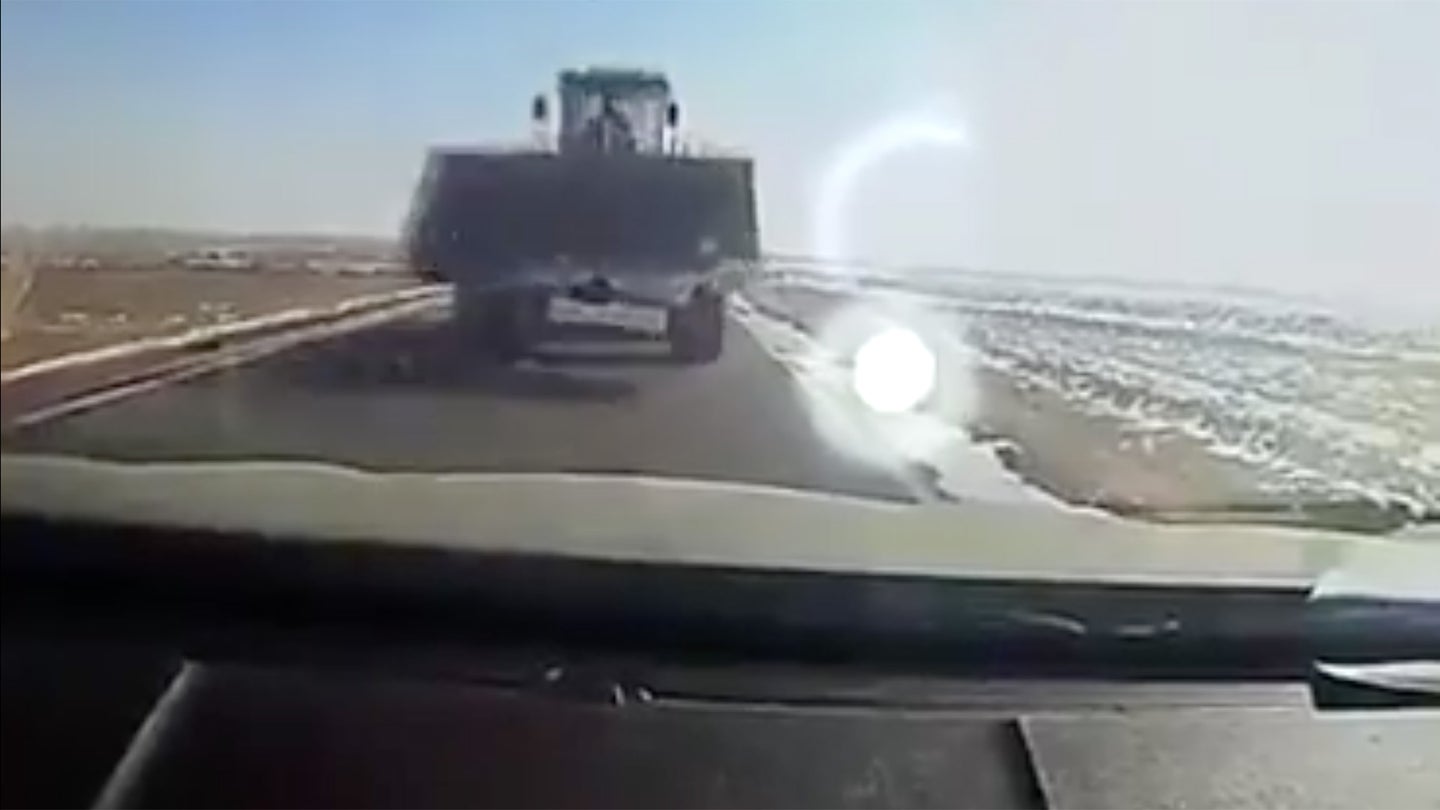 Front End Loader Nearly Decapitates Unsuspecting Driver in China