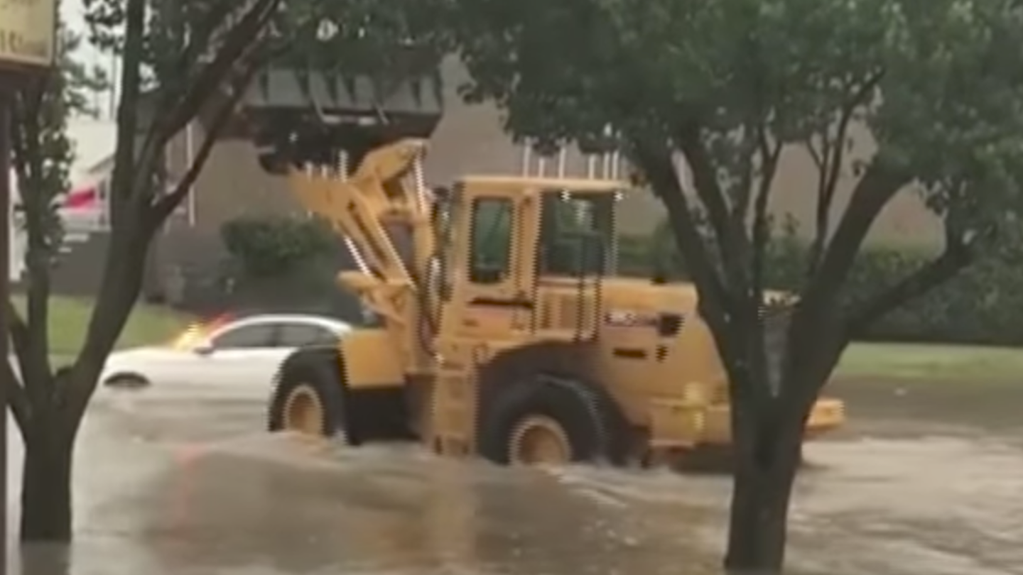 Watch a Front-End Loader Dump Water on a Burning Car in a Flood