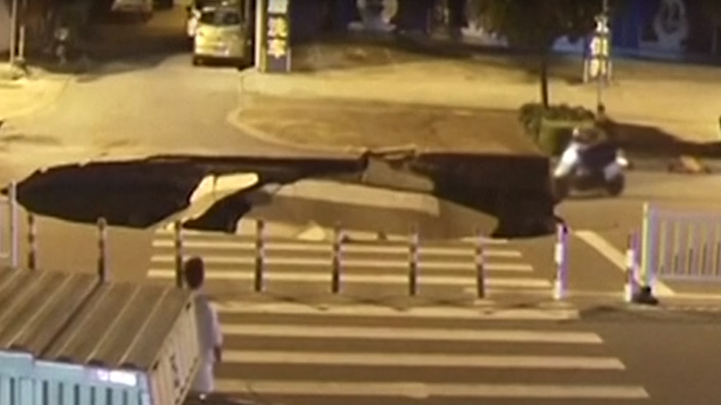 Watch This Distracted Driver Plunge His Scooter Straight Into a Sinkhole