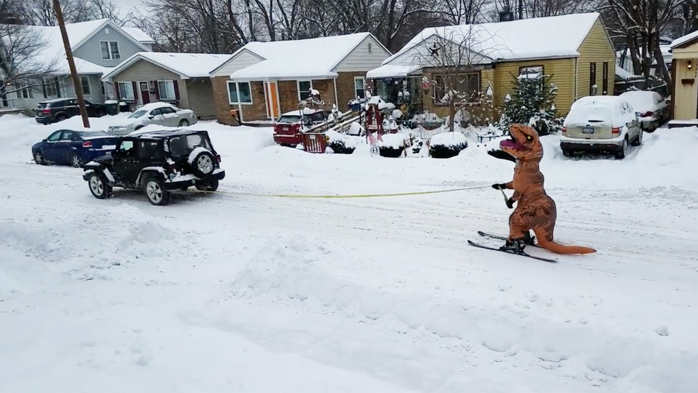 Watch This Skiing T-Rex Chase a Jeep Wrangler Down a Michigan Street