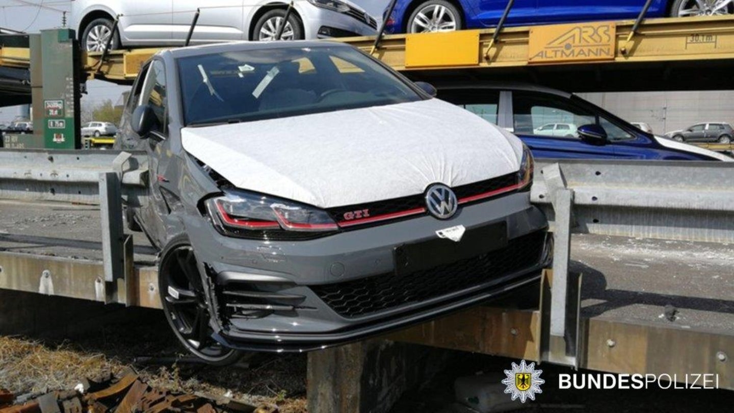 A crashed Volkswagen Golf GTI is wedged in between two guard rails.