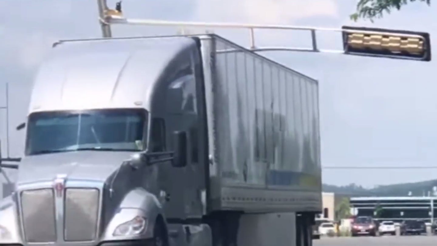 Oblivious Semi Truck Driver Crashes Into Traffic Light, Takes Entire Post for a Ride
