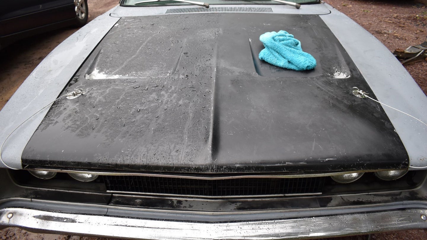 A microfiber drying towel on the hood of a classic Dodge Charger.