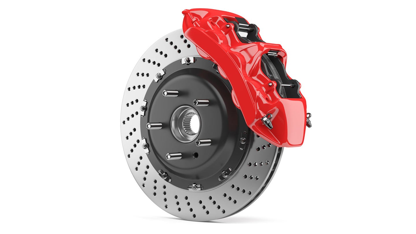 Automobile braking system. Aeration steel brake disk with perforation and red six pistons calipers and pads. Tuning auto parts. Isolated on white background 3d.
