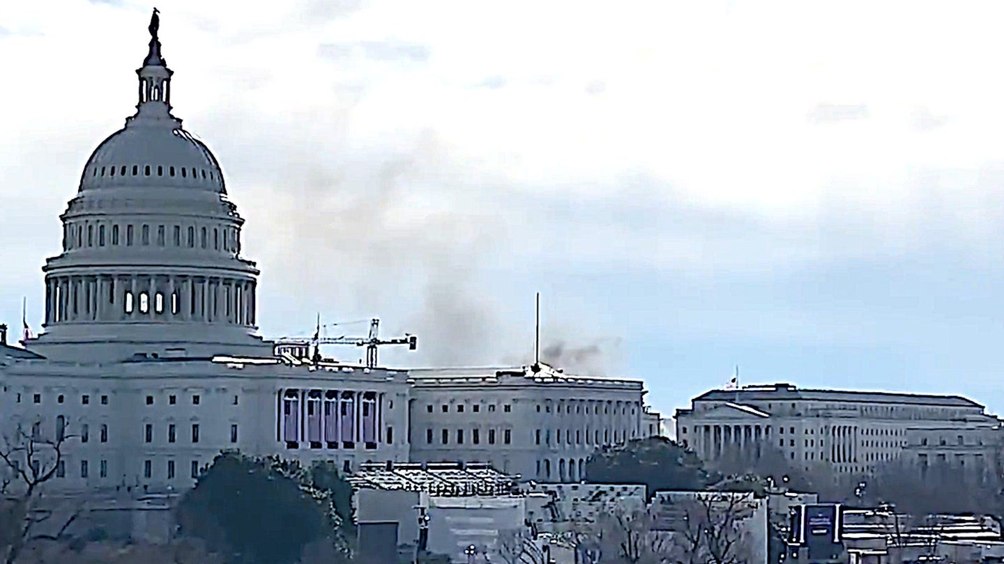 Smoke is seen rising behind the Capitol from a nearby fire on Jan. 18, 2021.