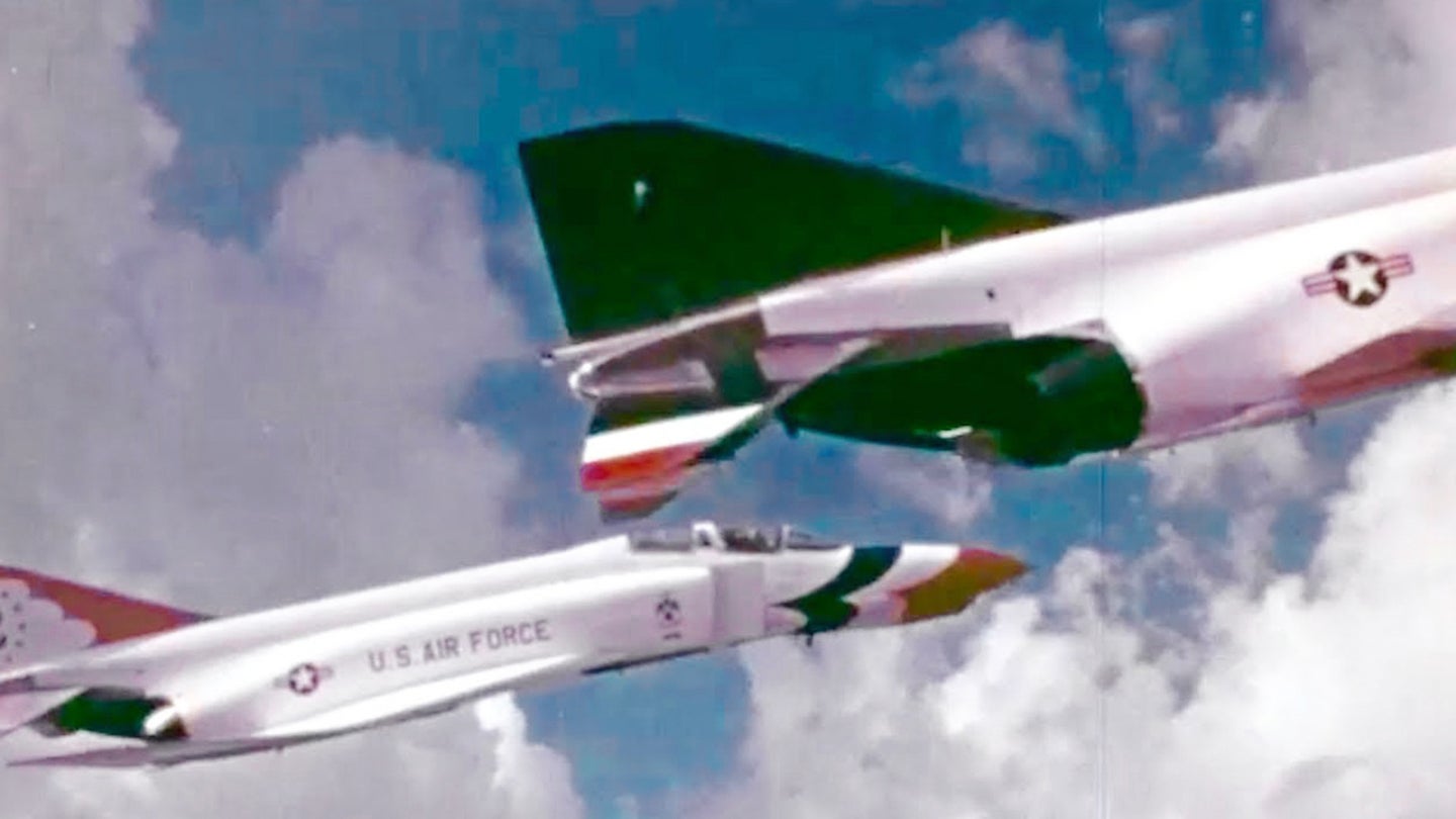 The tail of a Thunderbird F-4E Phantom II fighter jet is seen as another one flies in the background.