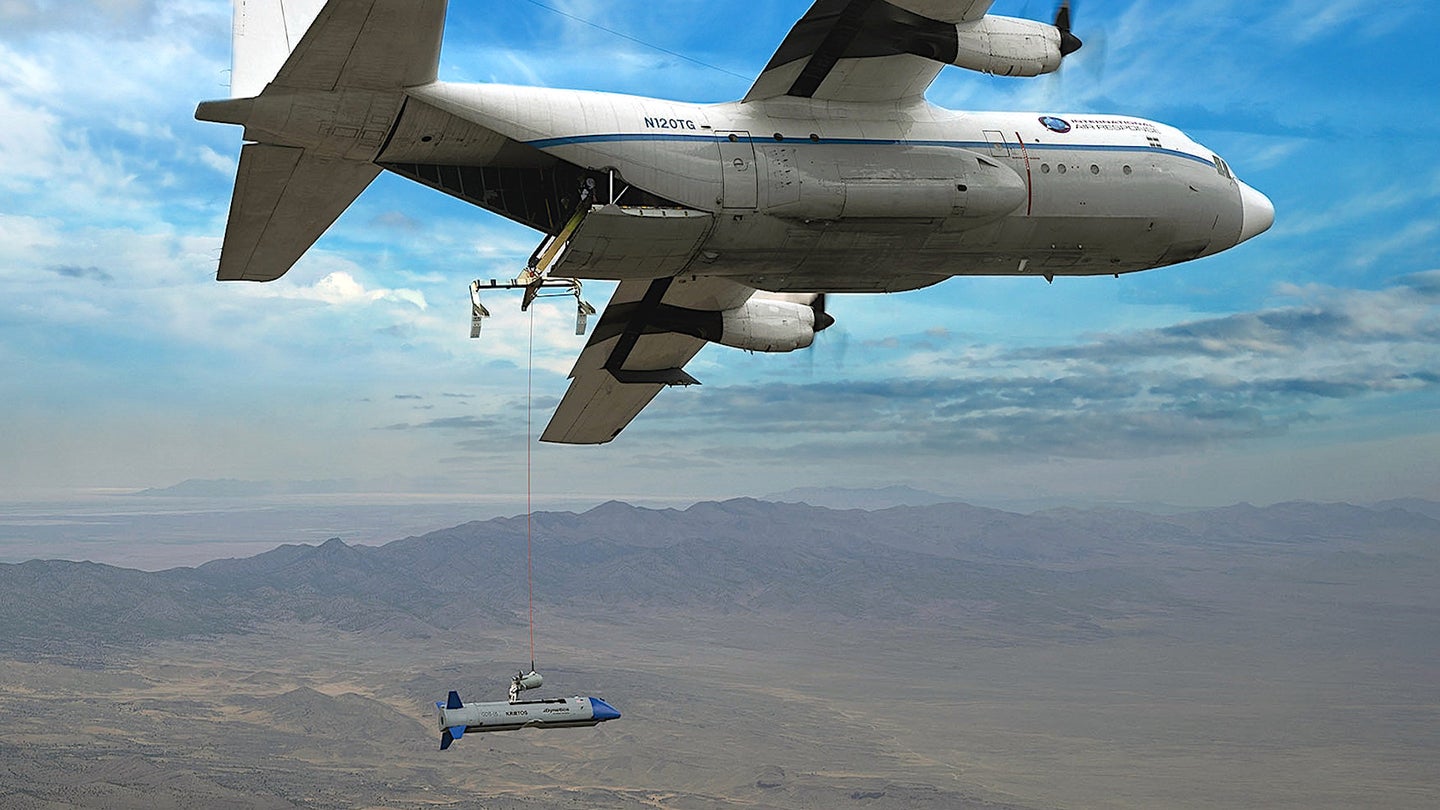 An X-61A Gremlins drone trails behind a C-130-type aircraft during a flight test.