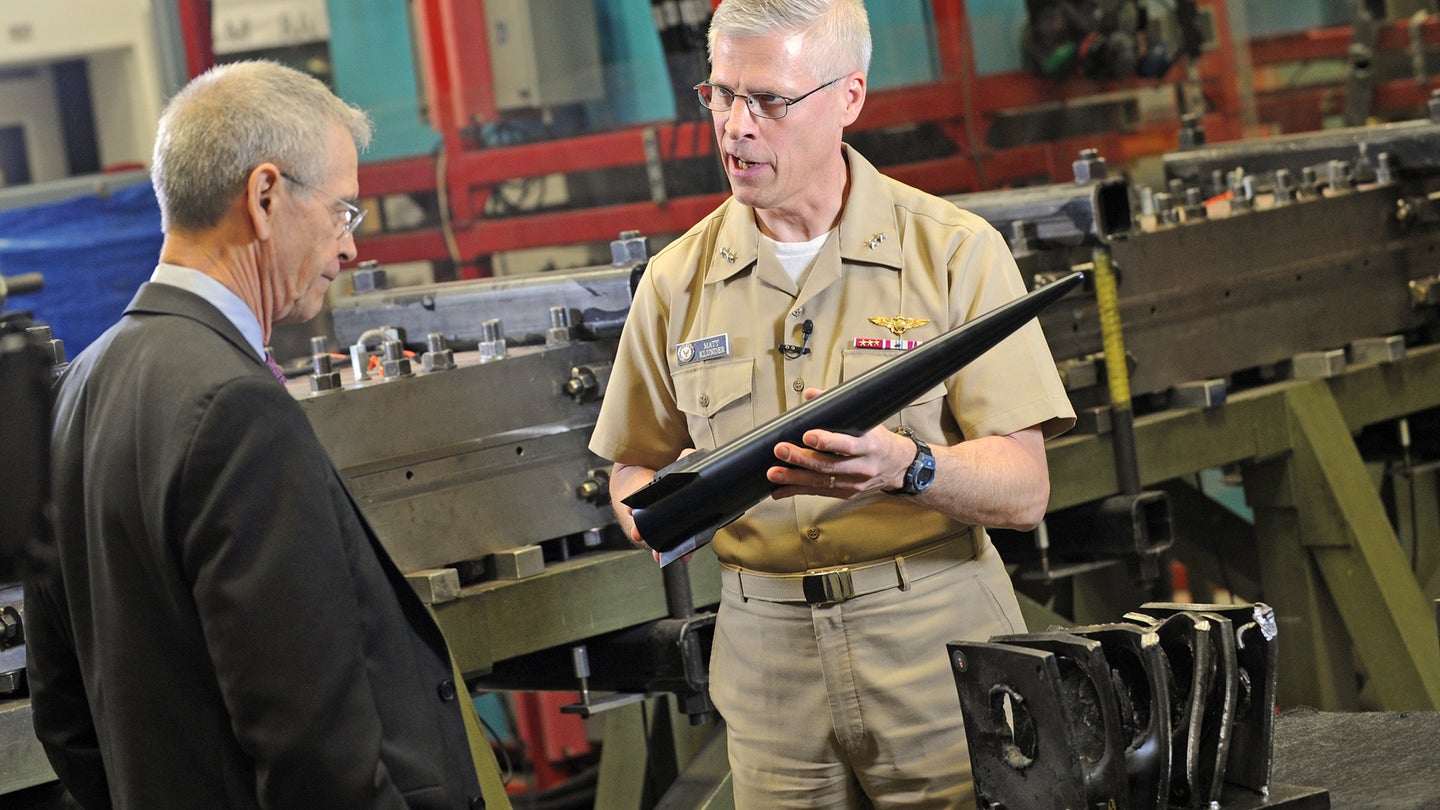 Then-Rear Adm. Matthew Klunder, chief of naval research, shows off a Hypervelocity Projectile (HVP) to CBS News reporter David Martin, during an interview held at the Naval Research Laboratory's materials testing facility in 2014.