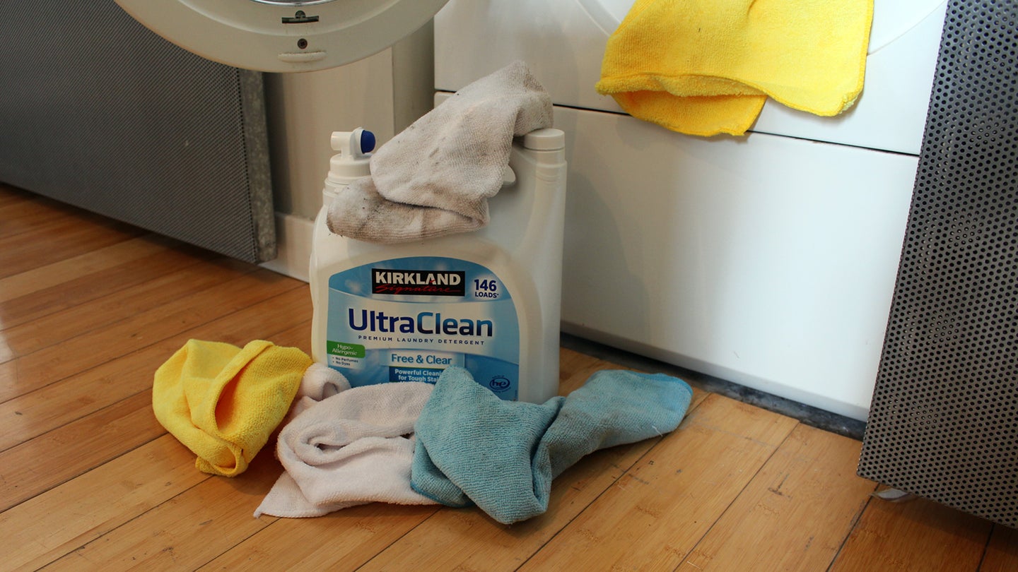 Kirkland Free and Clear laundry detergent with microfiber towels next to a washing machine.
