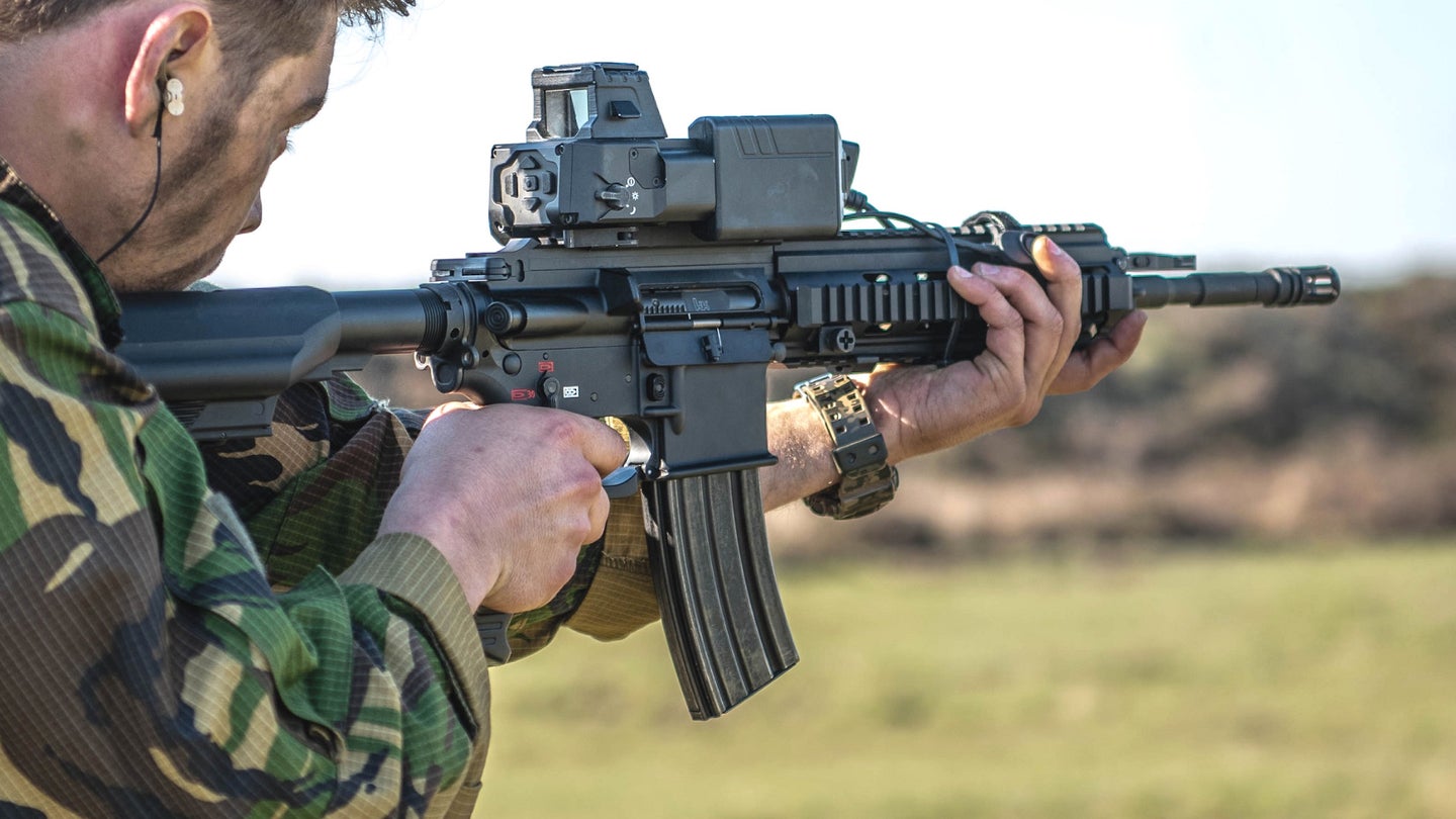 An individual holds a carbine equipped with the SMASH 2000 sighting system.